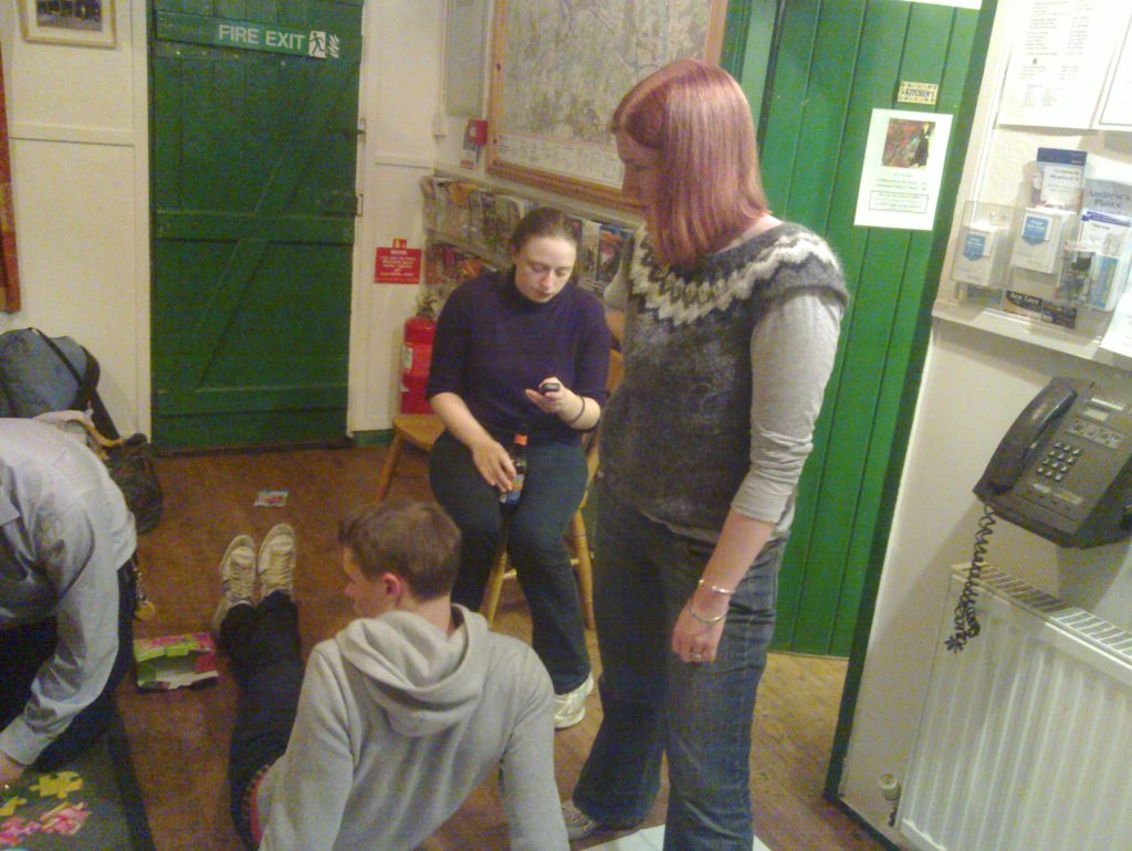 Sian stands with one foot on the mat as her team-mates struggle to complete their first challenge.