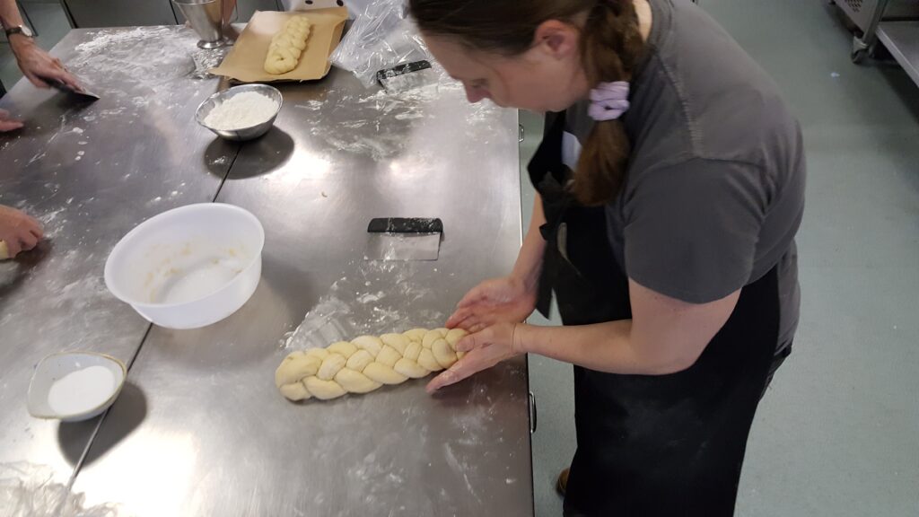 Ruth shapes her woven challah loaf.