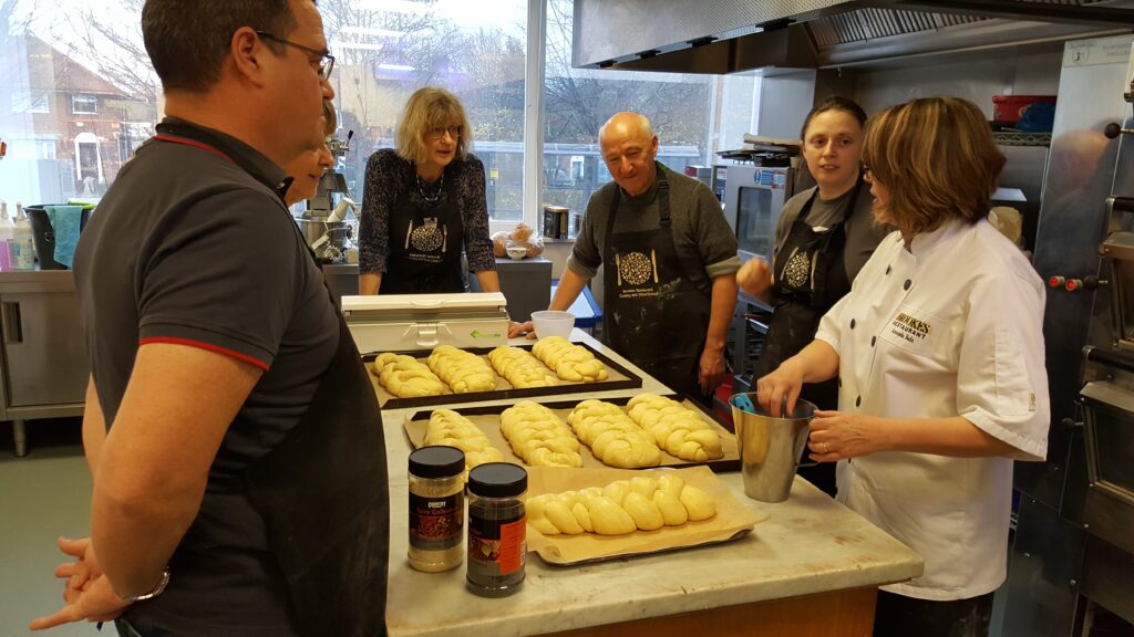 Glazing and seeding bread before it goes into the oven.