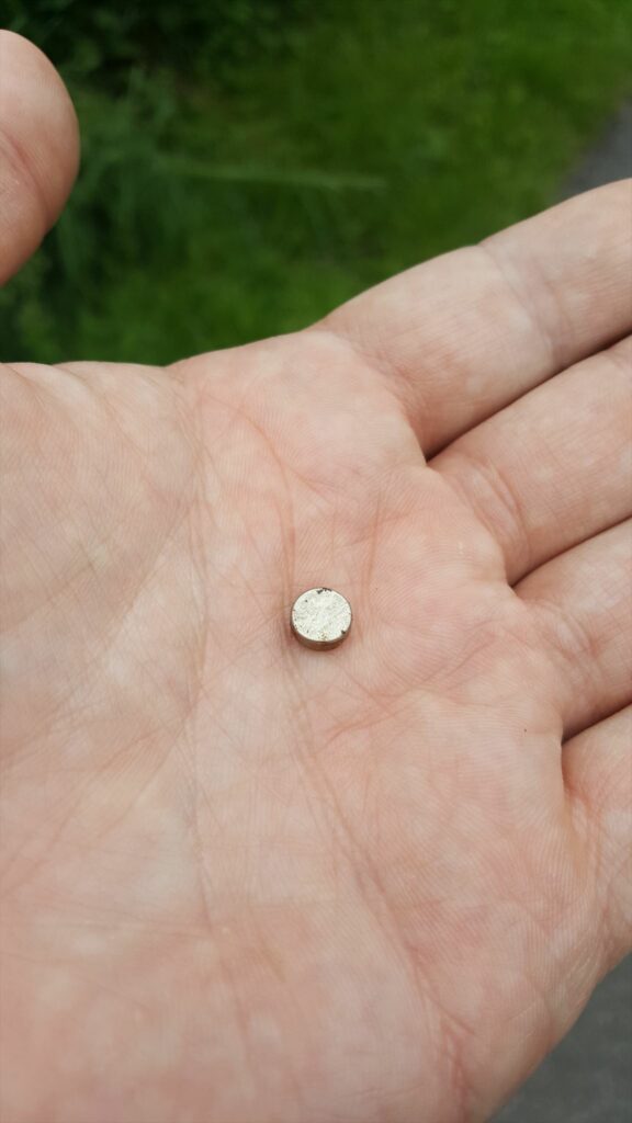 Nano cache magnet, detached, in Dan's hand.