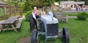 Annabel drives a tractor (with John on the back).