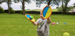 John catches a ball using a velcro-mitt.
