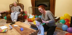 Auntie Sarah brushes Annabel's hair.