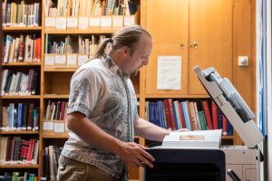 Dan uses the photocopier.