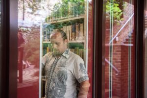 Dan in the library, viewed through the window.