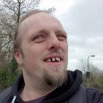 Dan grinning as he walks along the road