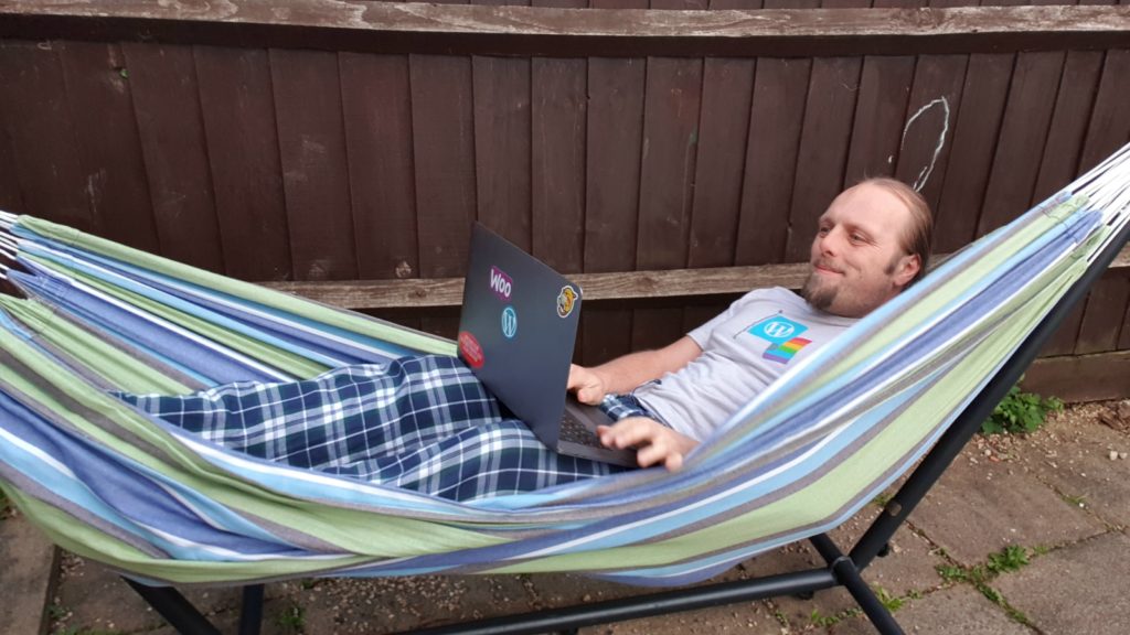Dan in a video meeting, in a hammock.