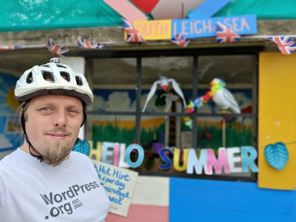 Dan outside a disused bus stop repurposed as a "beach hut".