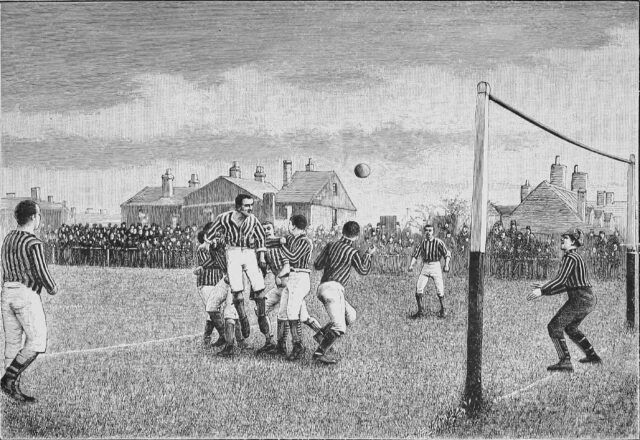 Monochrome line drawing showing a 19th century scene of a football match. The ball appears to have been headed towards the goal by a jumping player; the goalkeeper is poised to dive for it.