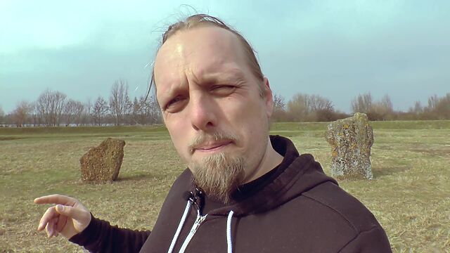 Video screengrab of Dan standing in front of some standing stones.