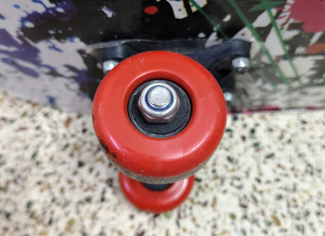 Close-up of a red wheel on a skateboard.