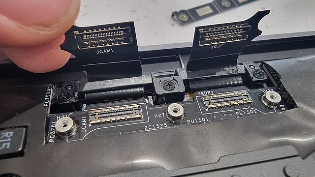 Close-up of tiny sockets on ribbon cables within the housing of a laptop.