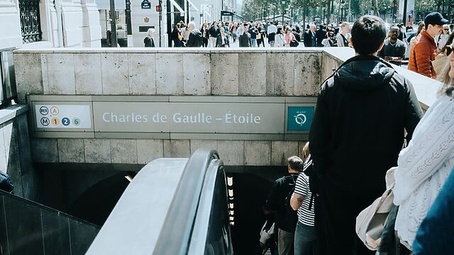 Crowds file down the escalator into Charles de Gaulle-Étoile station.