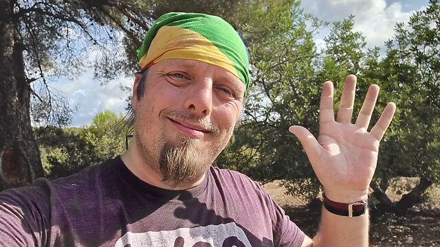 Dan waves in a bright forest.