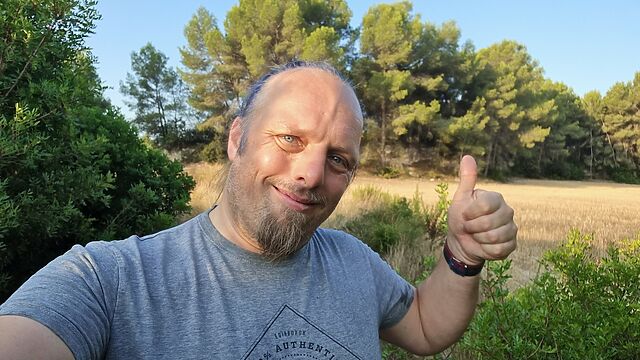 Dan throws a 'thumbs up' to the camera.