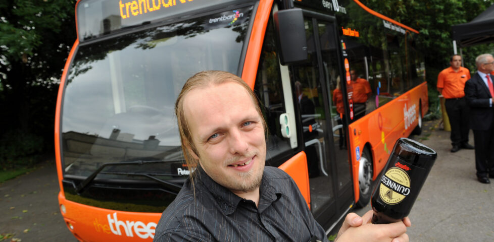 I hold a bottle of Guinness in preparation of "breaking" it over the front of the bus.