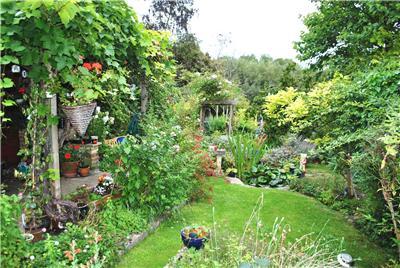 Full image of A well-maintaned and lively garden stretches away.