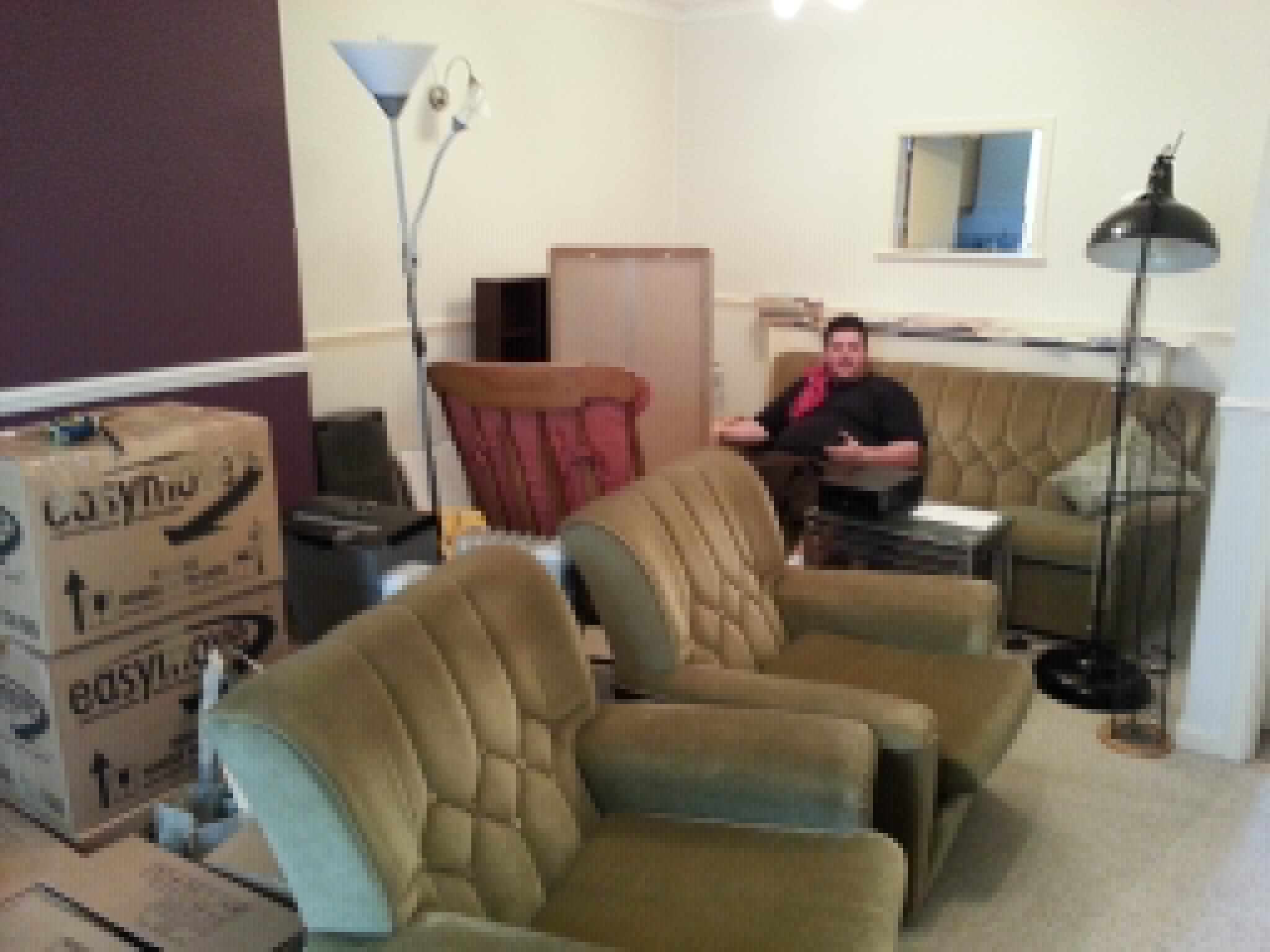 Full image of Alec among furniture and boxes.