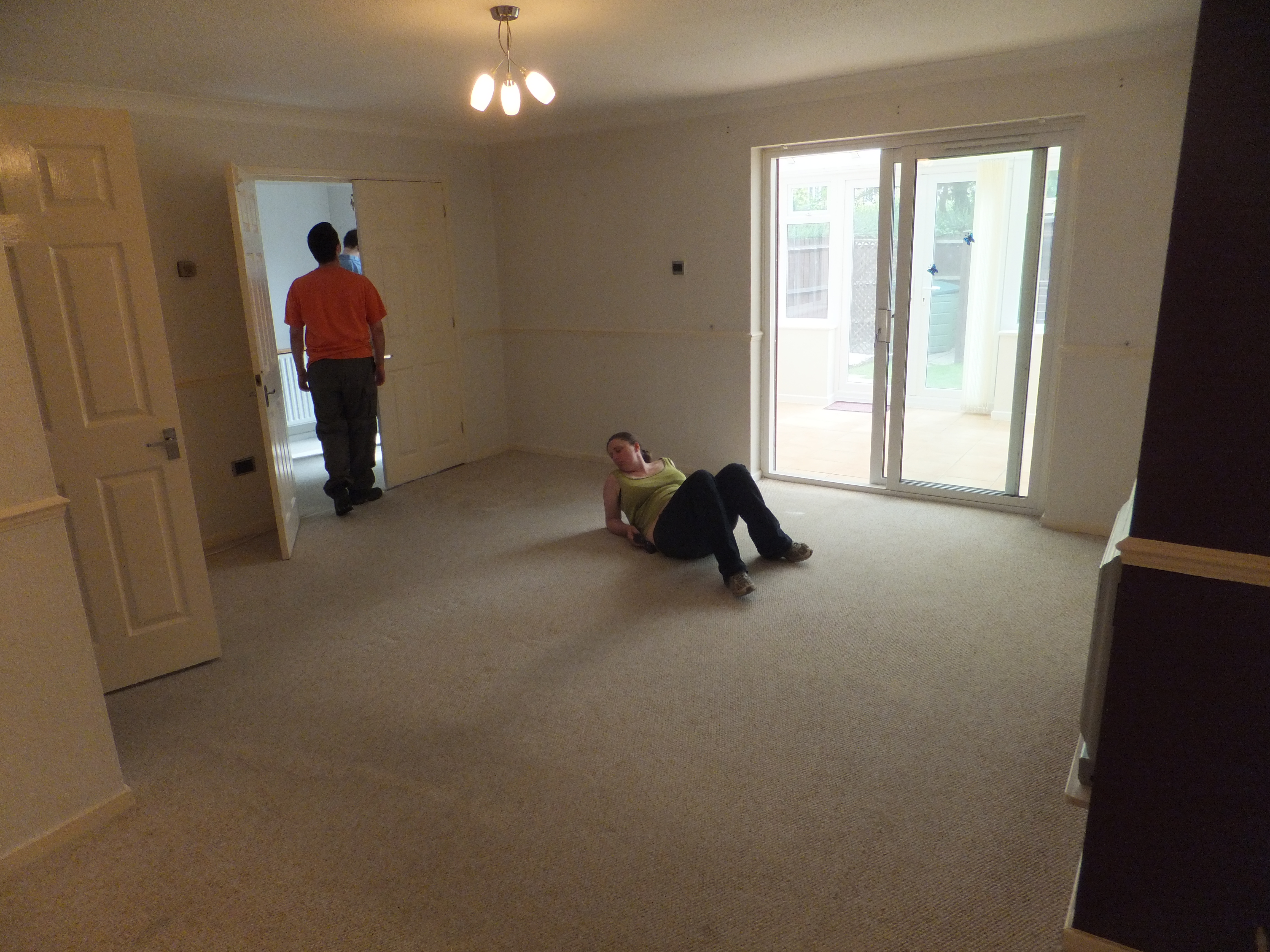 Full image of Ruth lies in the empty living room of Greendale.