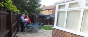 One of the existing owners talks to the surveyor as he inspects the conservatory.