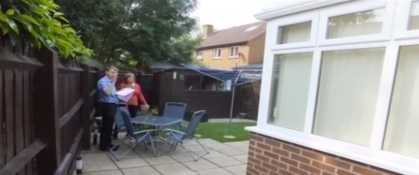 One of the existing owners talks to the surveyor as he inspects the conservatory.