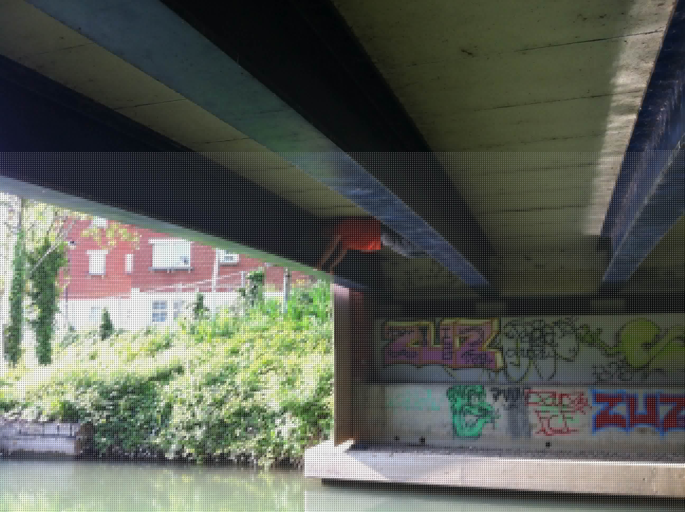 Full image of Dan, braced between two I-beams about 5 feet apart, underneath a bridge.