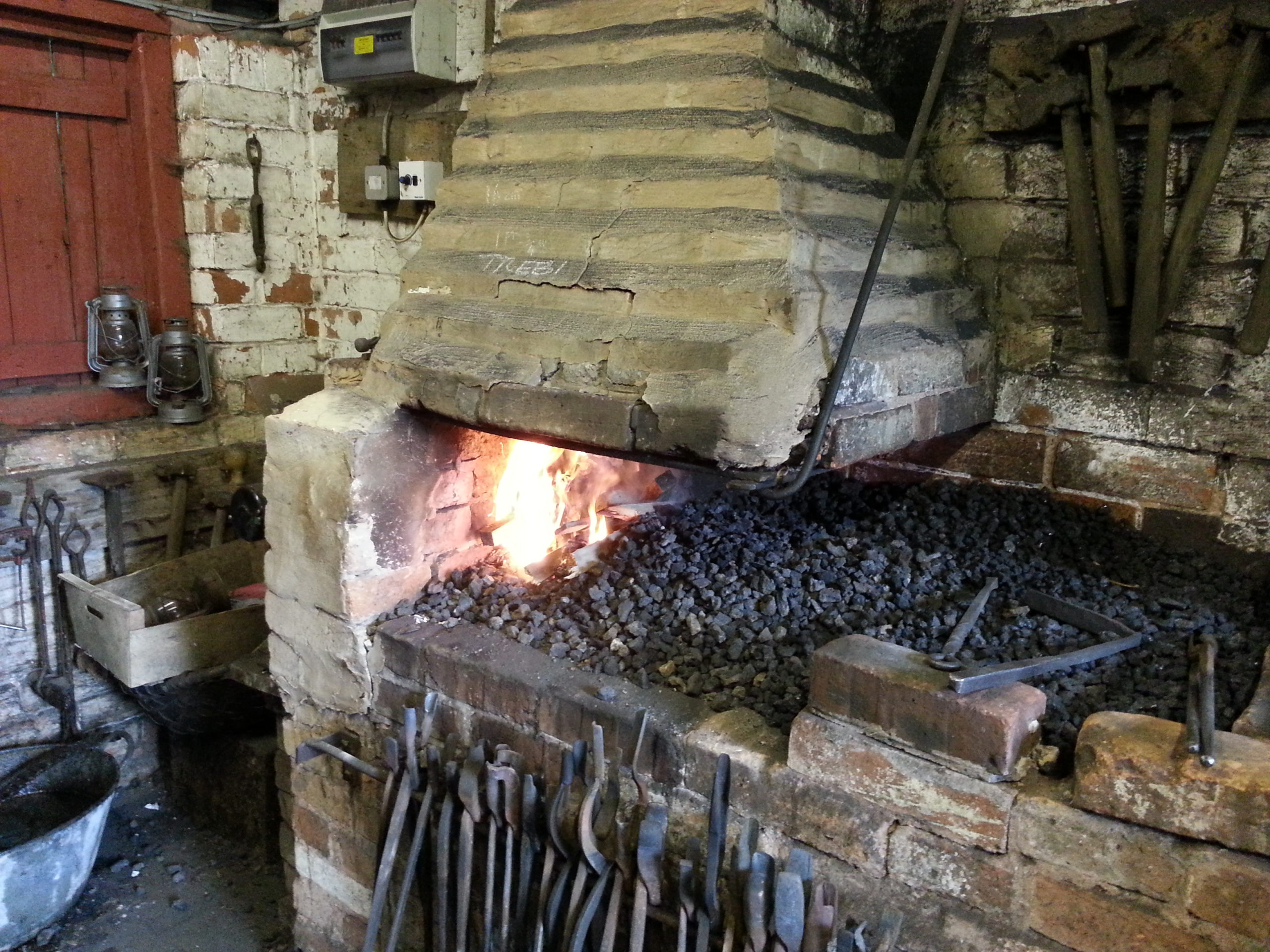 Full image of A blacksmith's hearth: the fire is just lit.
