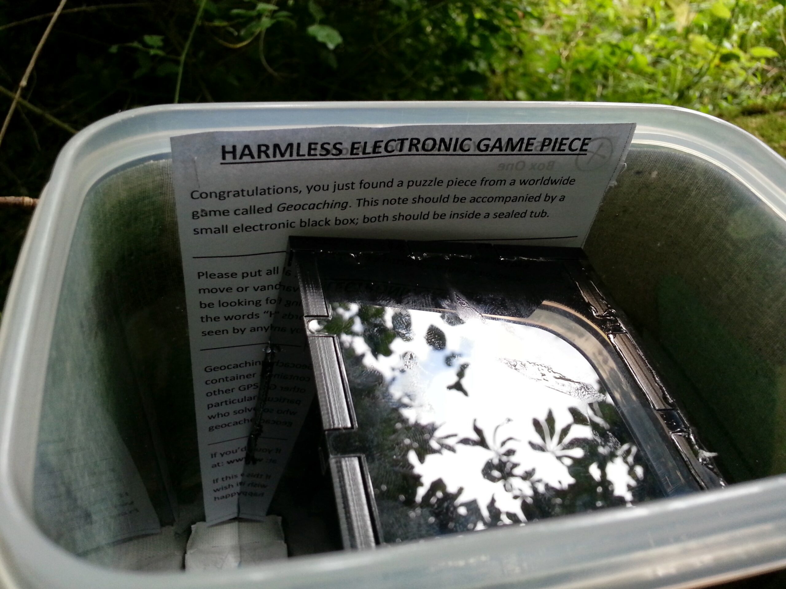 Full image of Harmless Electronic Game Piece, written above Box One, in situ