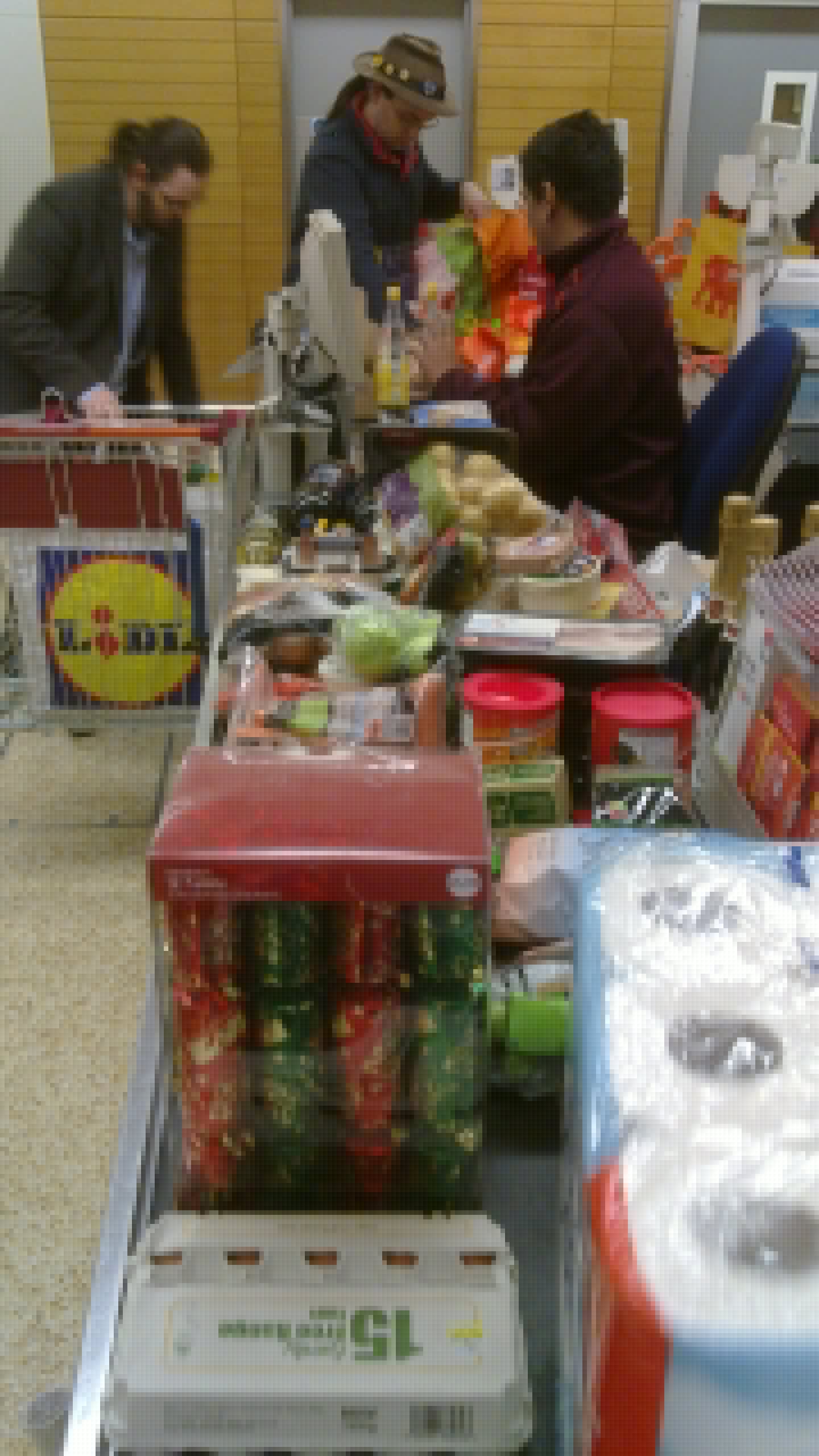 Full image of JTA and Paul pack bags at the checkout, before Christmas 2010.