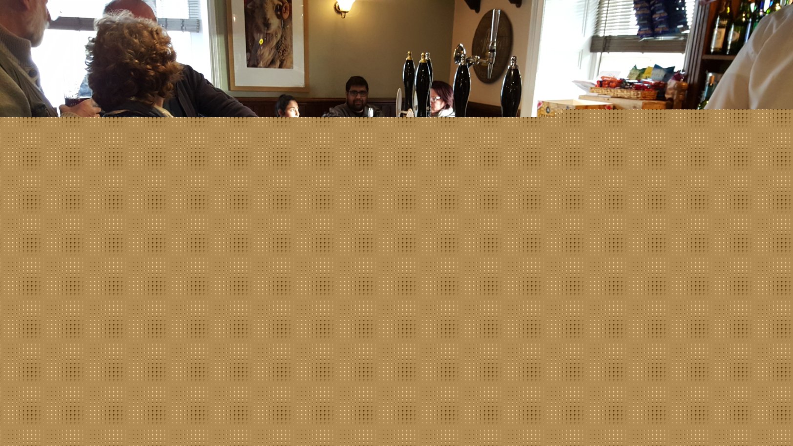 Full image of Annabel sitting at a bar in a pub.