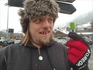 A geocache held by Dan, wearing a snow hat.