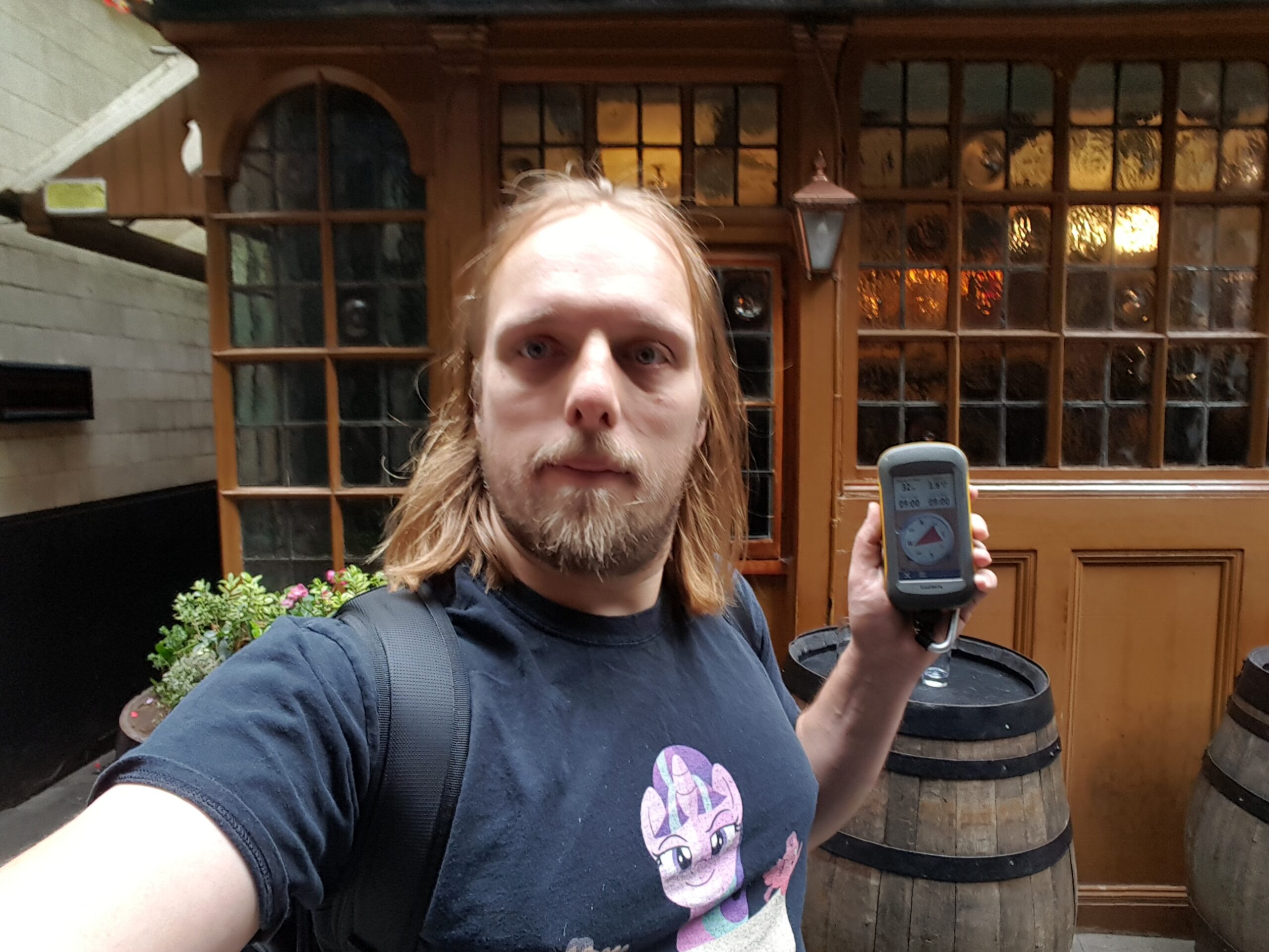 Full image of Dan, outside a pub, holding a GPS receiver.