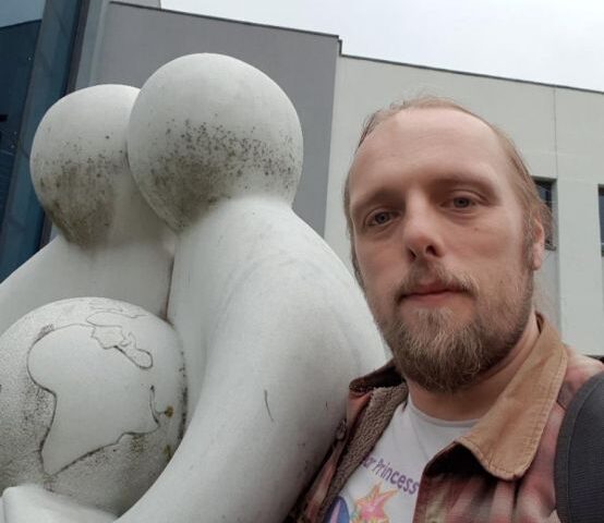 Dan and two statue-people holding a globe