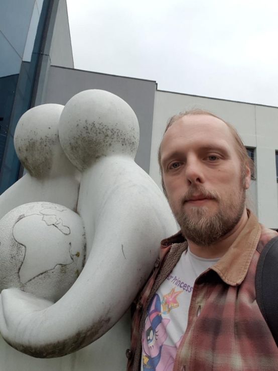 Dan and two statue-people holding a globe