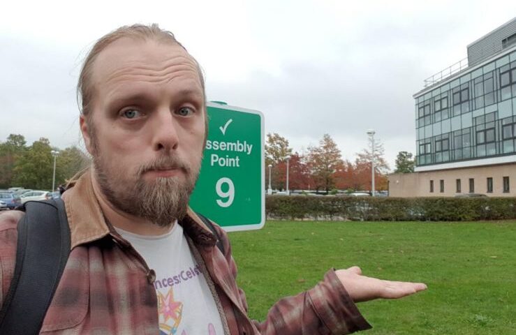 Dan at a Fire Assembly Point sign (at which there possibly once used to be a piece of artwork)