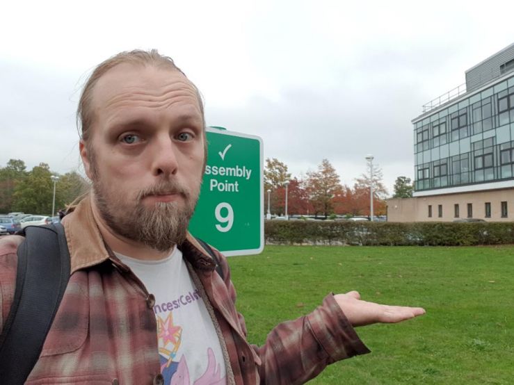 Dan at a Fire Assembly Point sign (at which there possibly once used to be a piece of artwork)