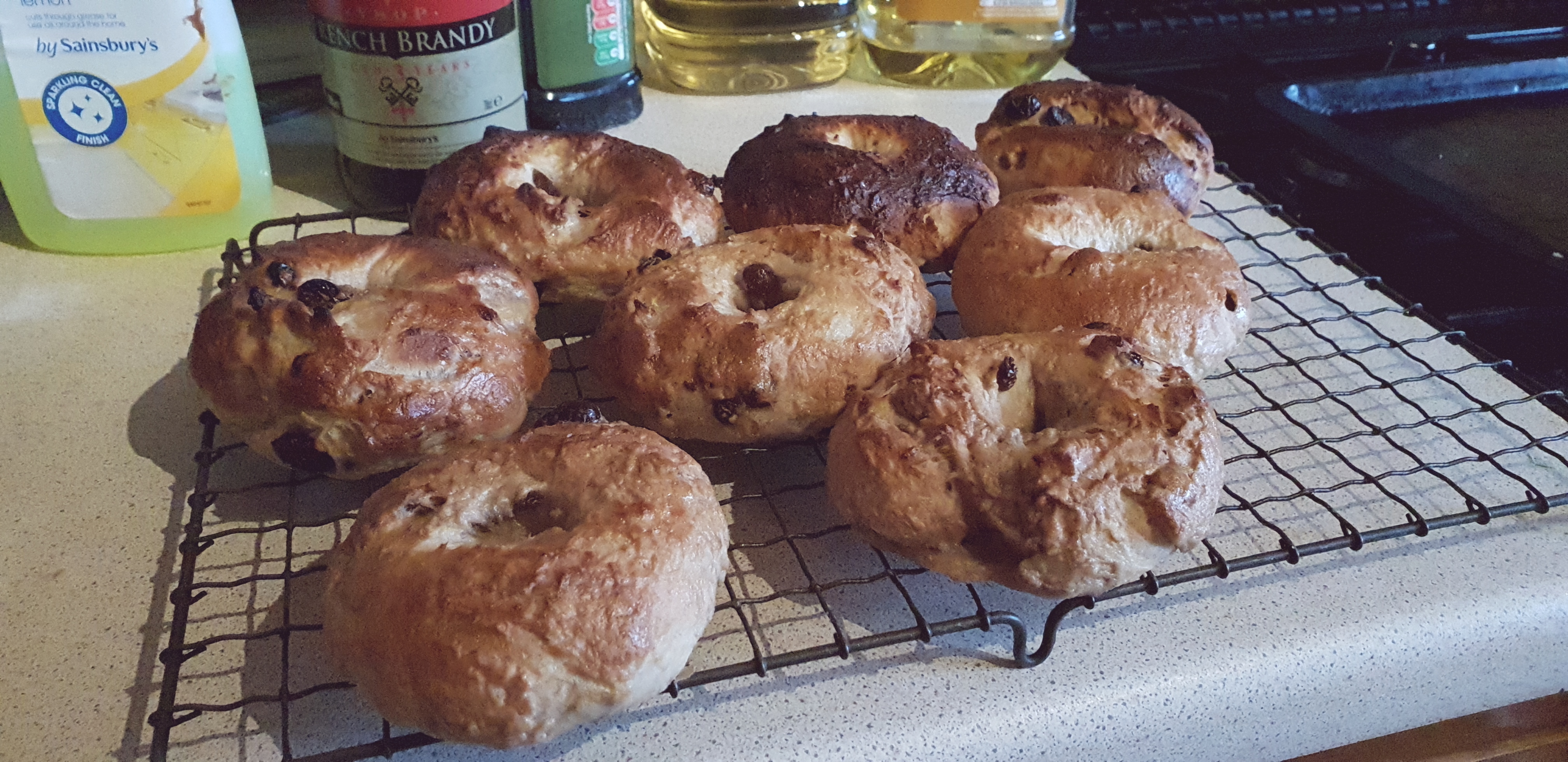 Full image of Cooling rack full of rustic bagels.