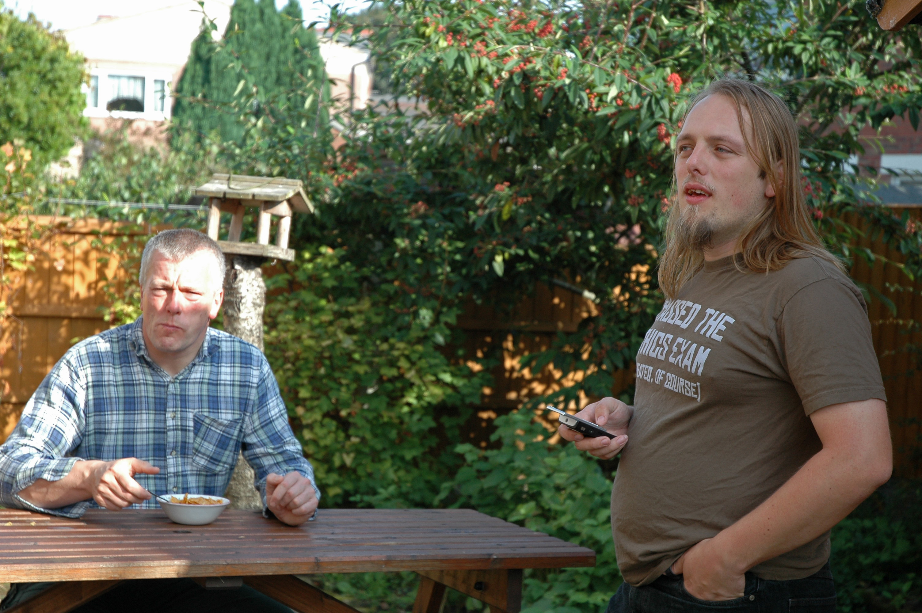 Full image of Dan and his dad have breakfast in the garden.