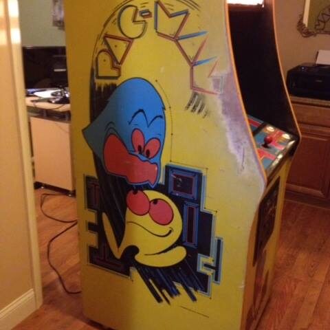 Unrestored Pac-Man machine with worn paint in a specific place on the left-hand side.