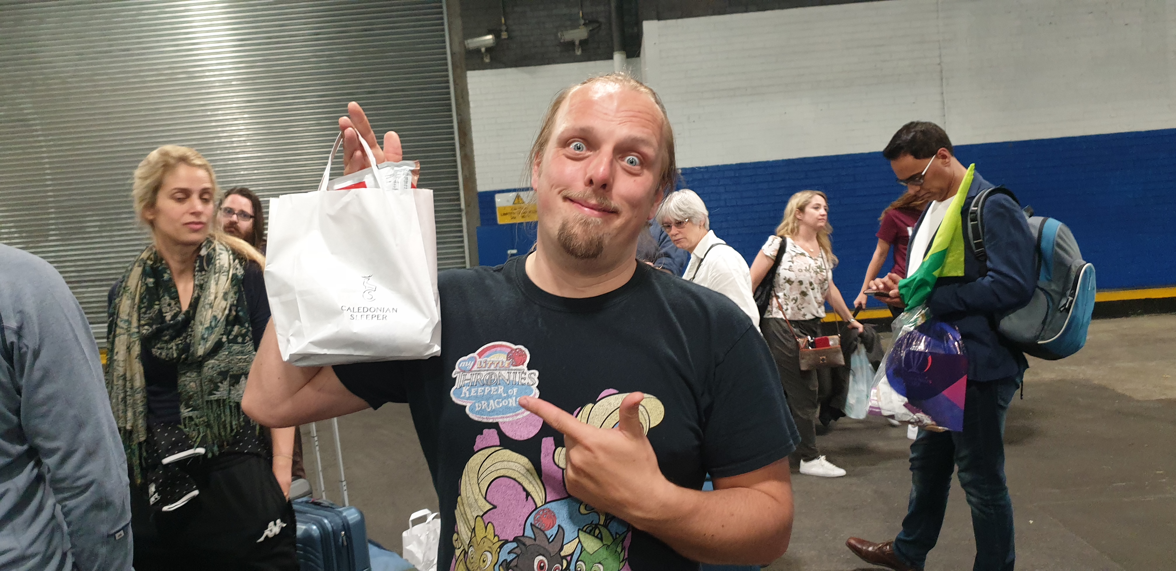 Full image of Dan with a bag of snacks and shit from the train crew.