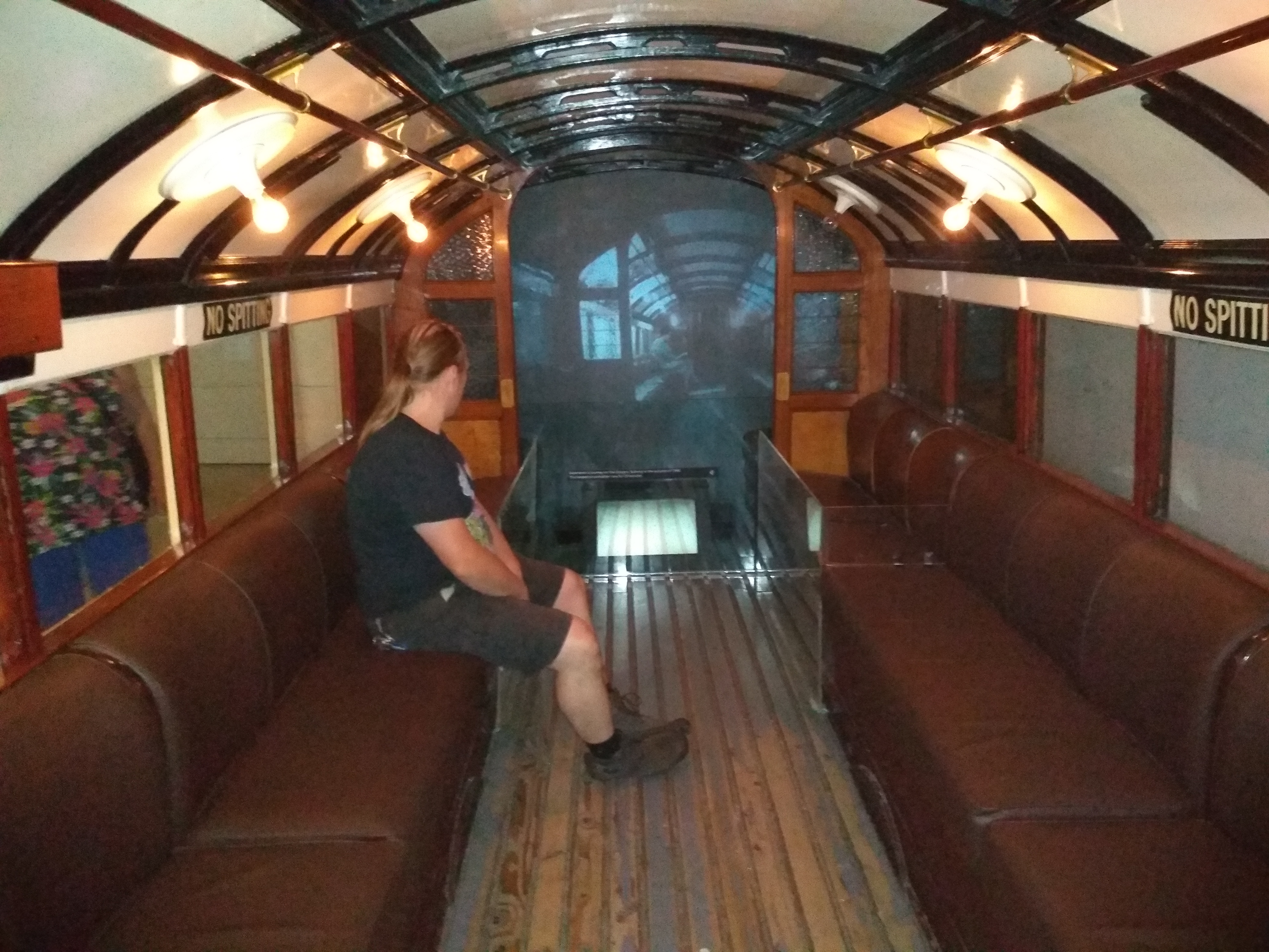 Full image of Dan sits aboard a replica of an original Glasgow subway train.