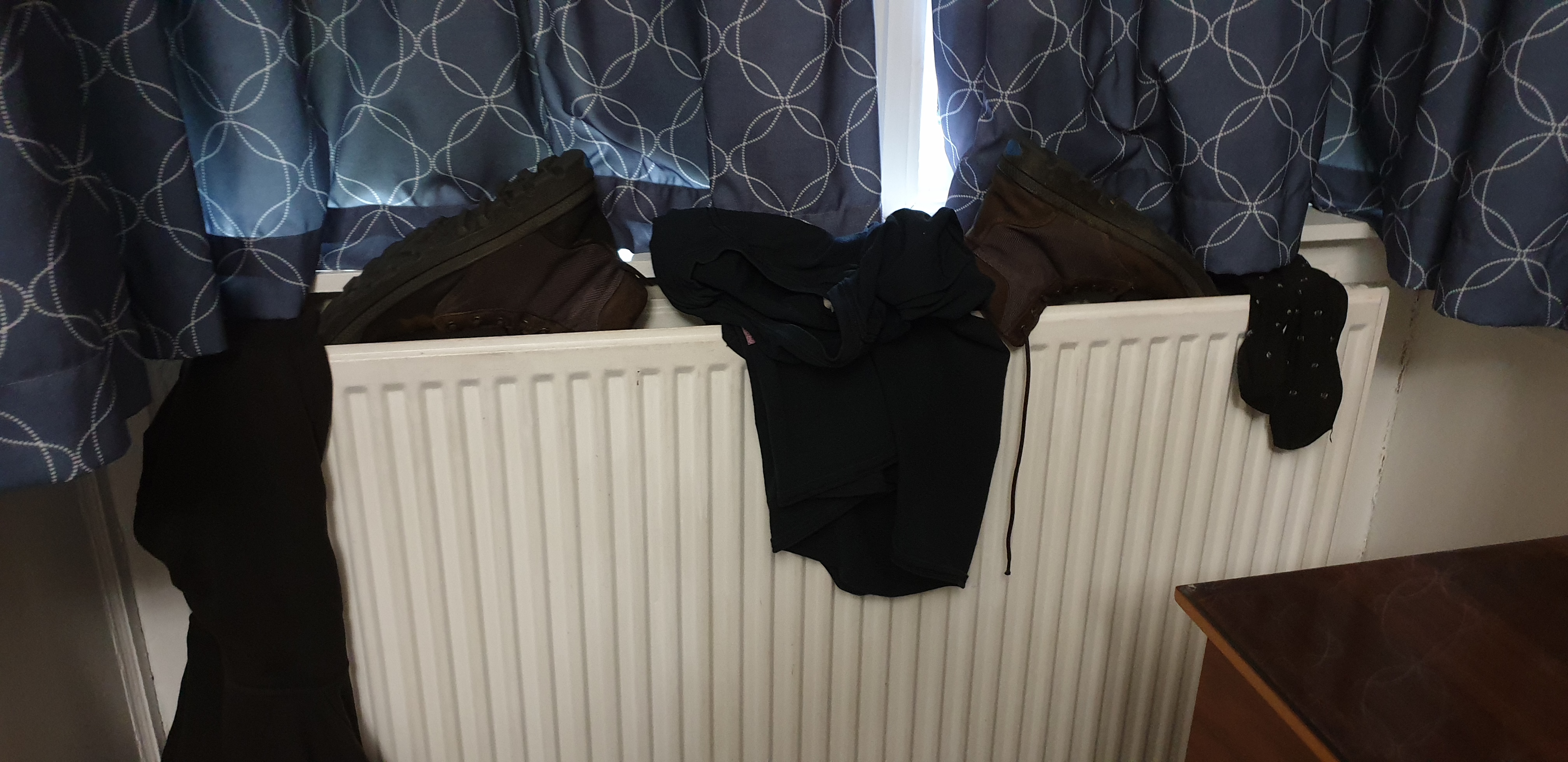 Full image of Clothes and shoes on a radiator.