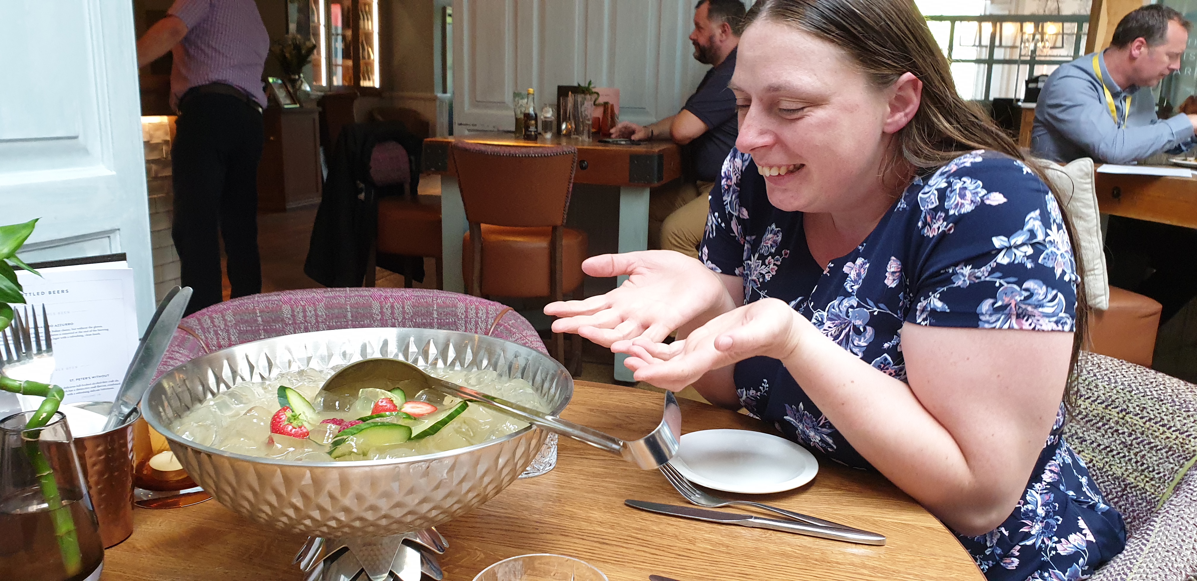 Full image of Ruth sits in awe of a bowl of gin cocktail.