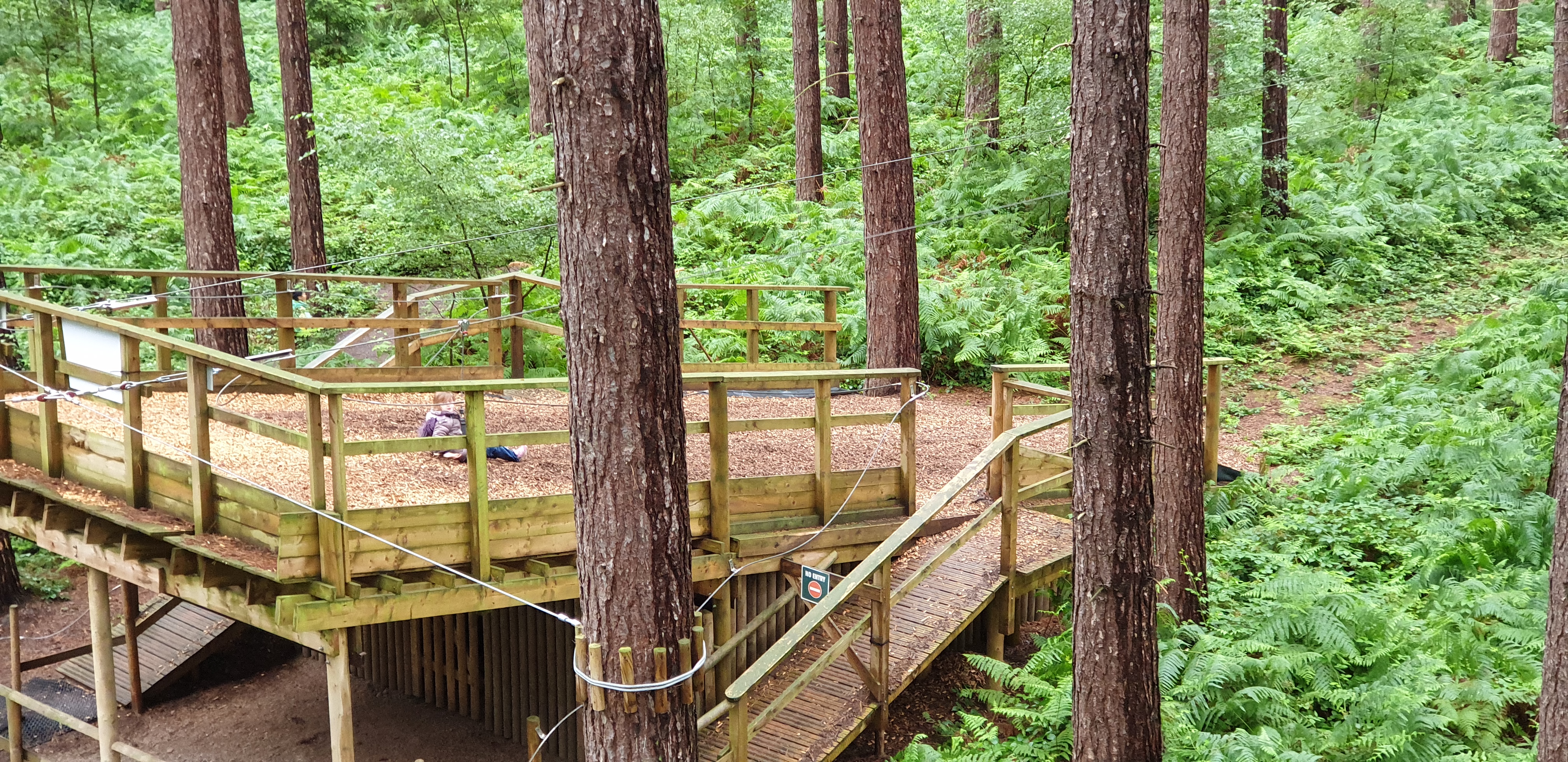 Full image of Annabel lands at the bottom of the zipline.