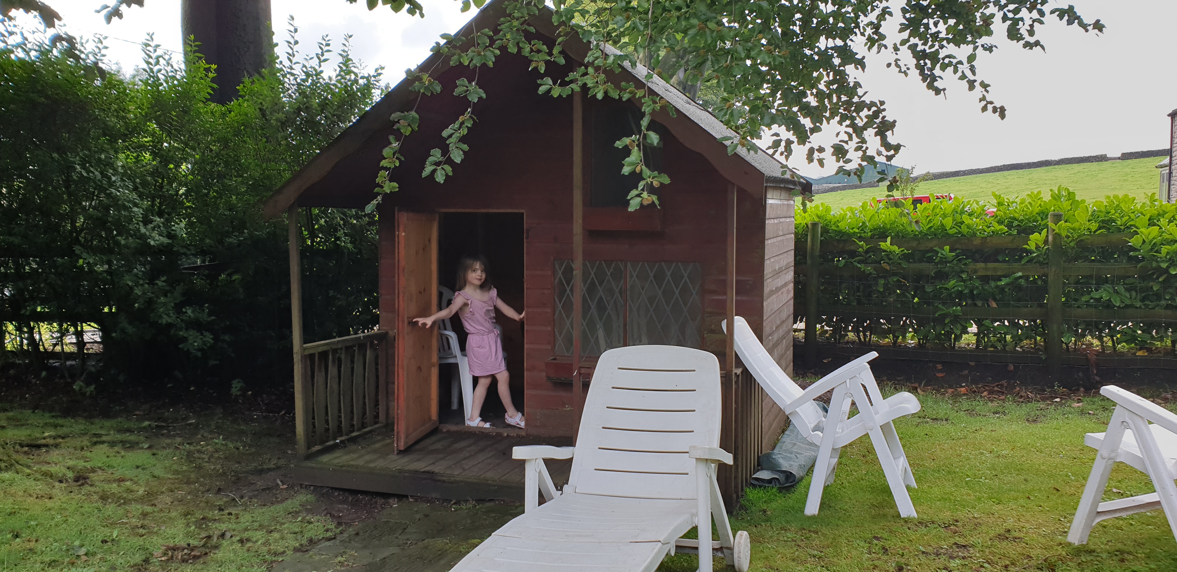 Full image of Annabel at the door of her playhouse.