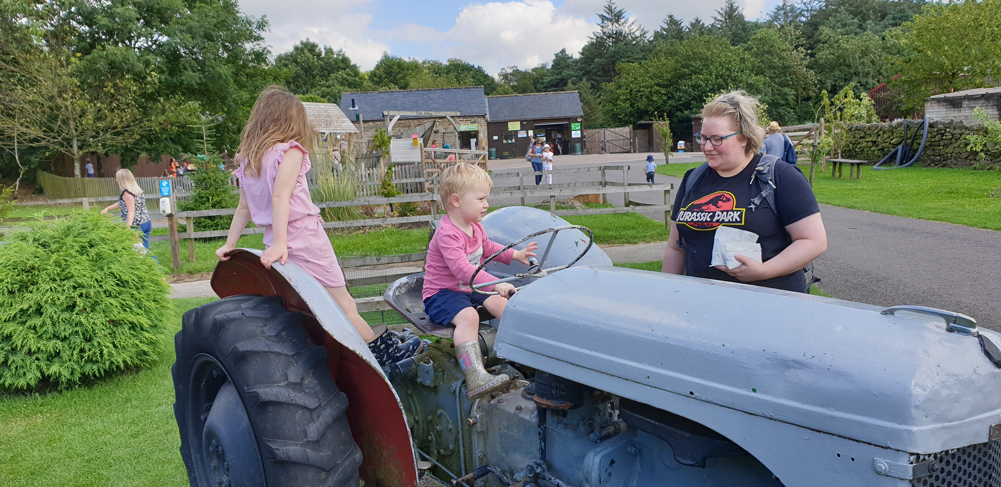 Full image of John drives a tractor (with Annabel on the back and Becky watching).