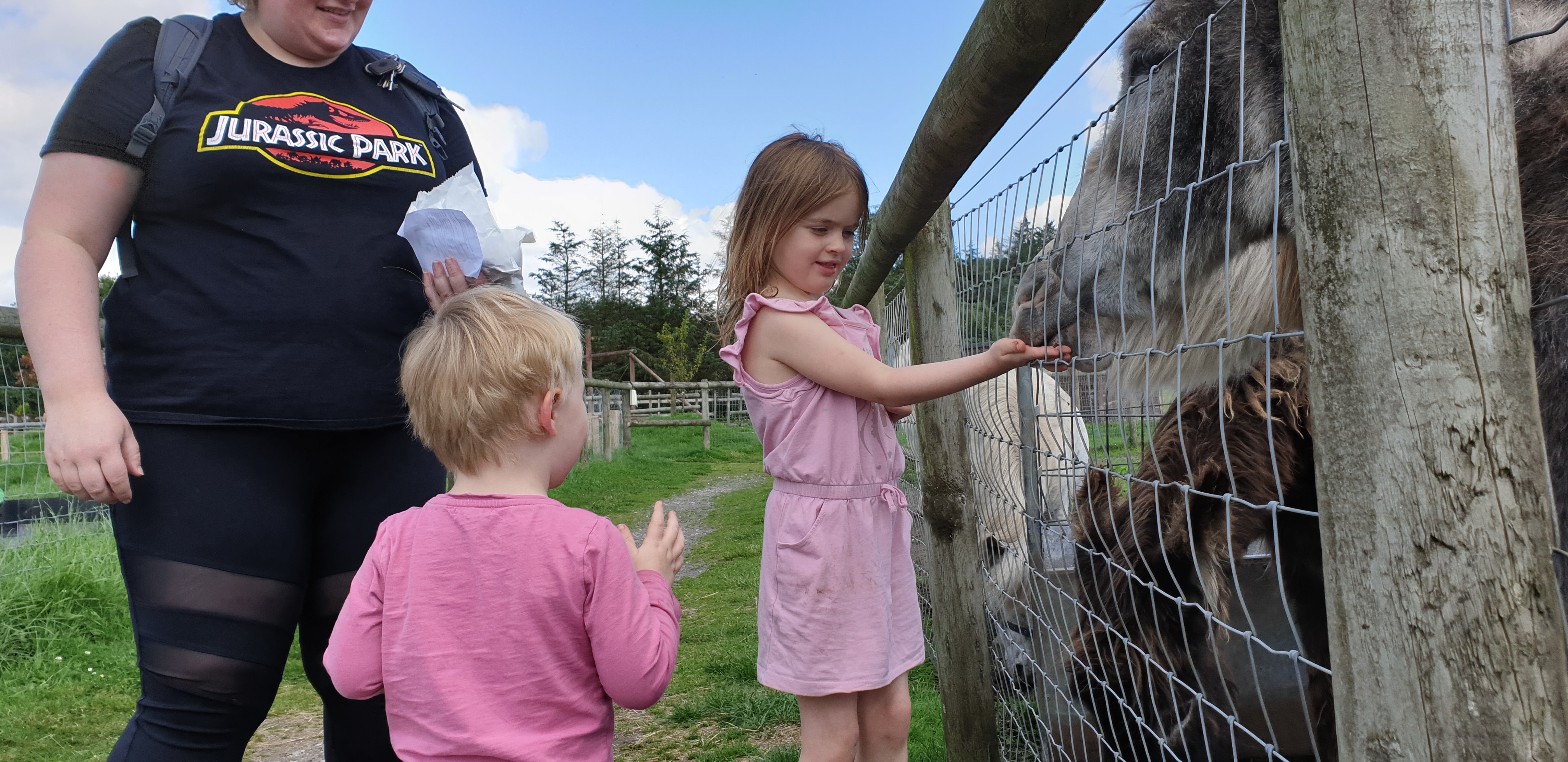Full image of Annabel shows John how to feed the animals.