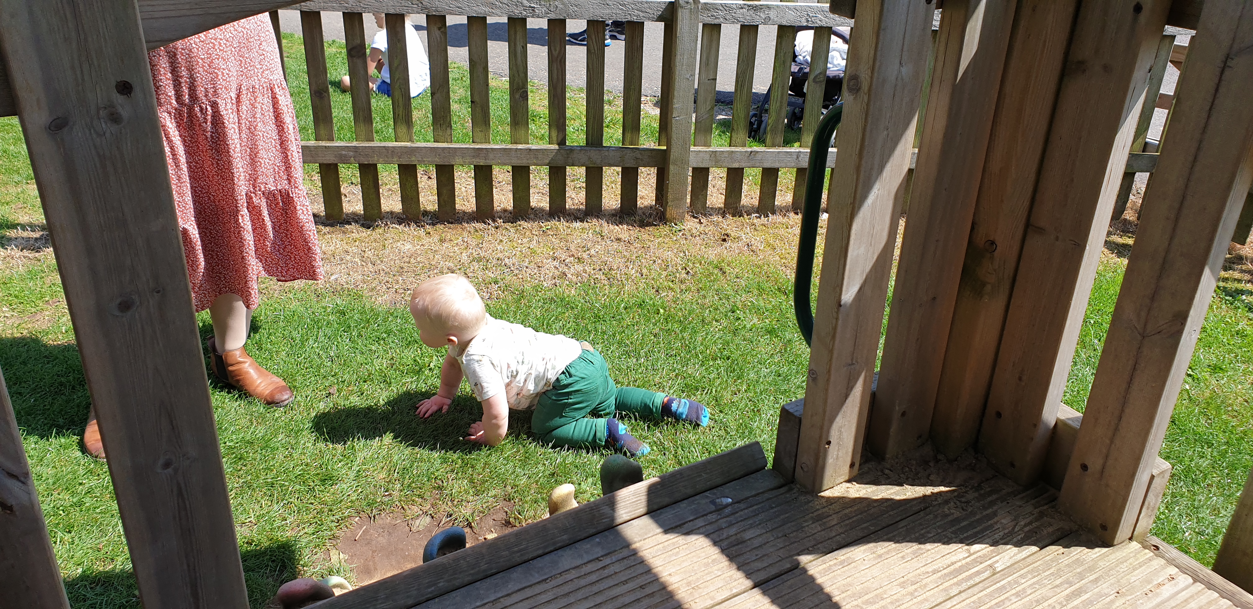 Full image of One of the twins crawls around the play area.