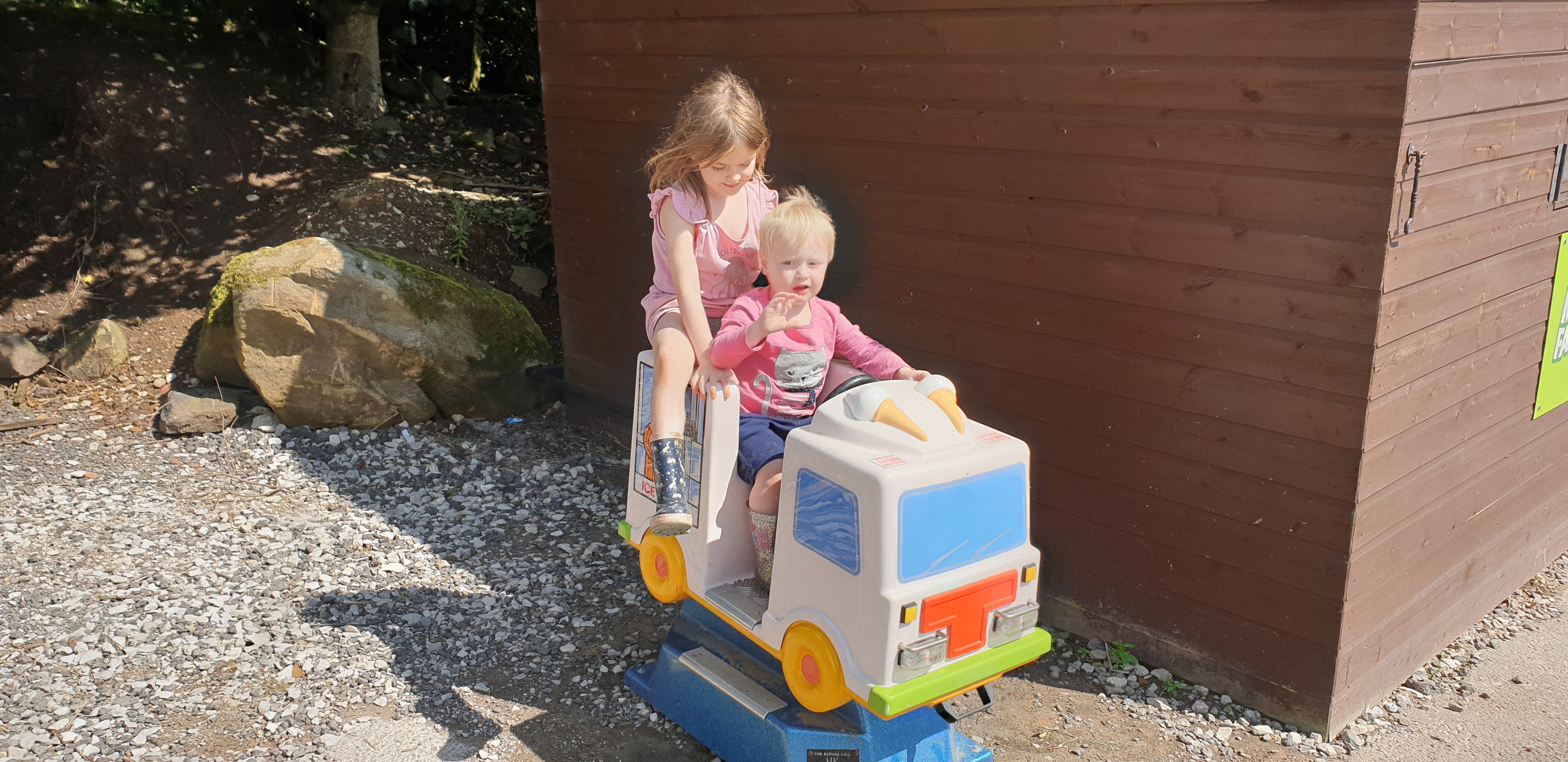 Full image of John and Annabel ride a sit-on ice cream van.