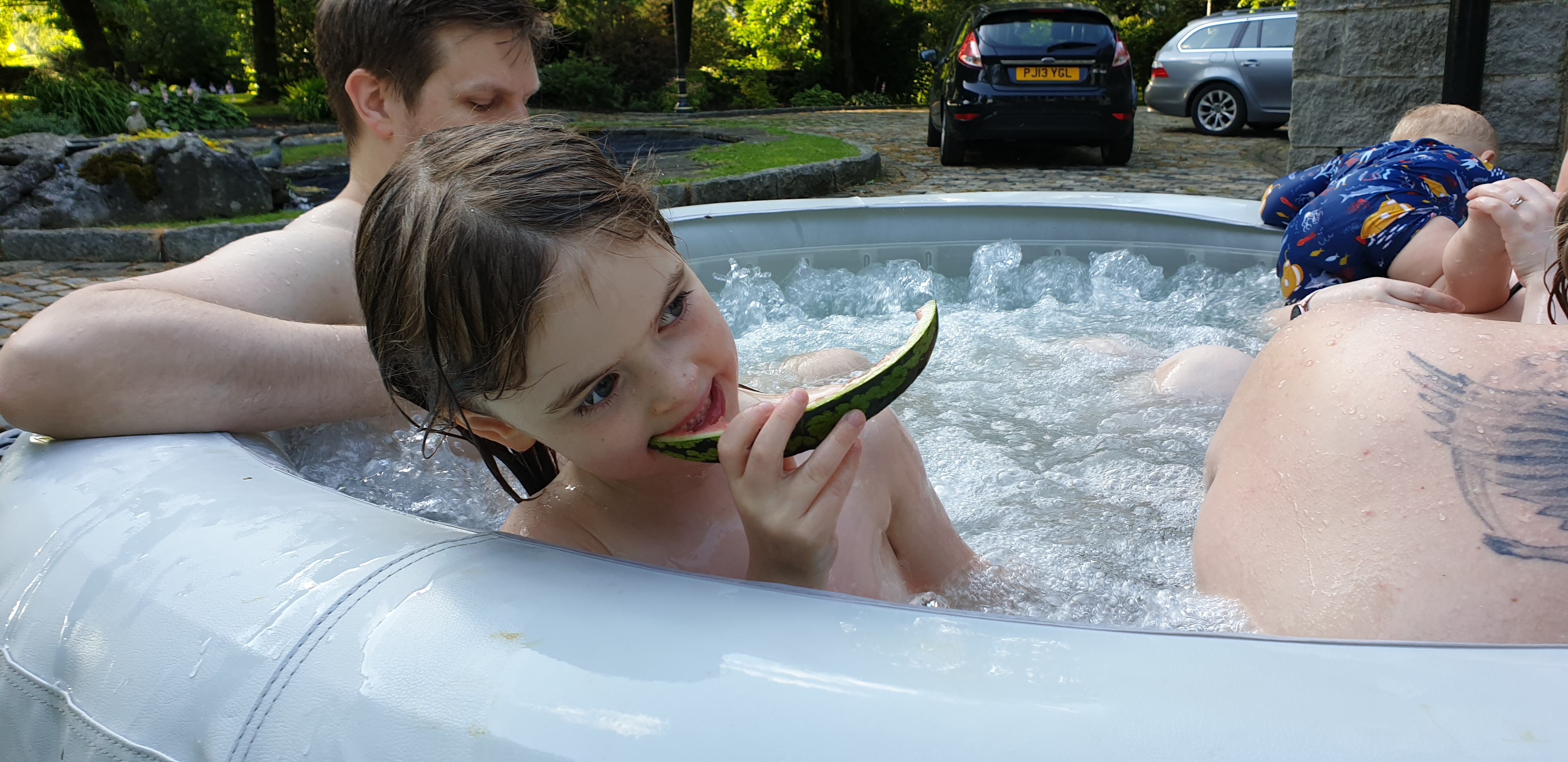 Full image of Annabel eats watermelon in the hot tub.